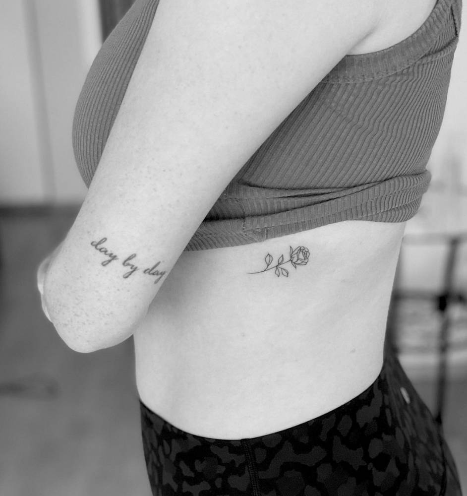Fine line rose tattoo on the rib.
