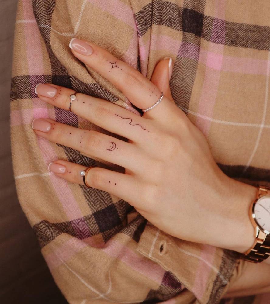 Hand poked ornamental tattoos on the finger