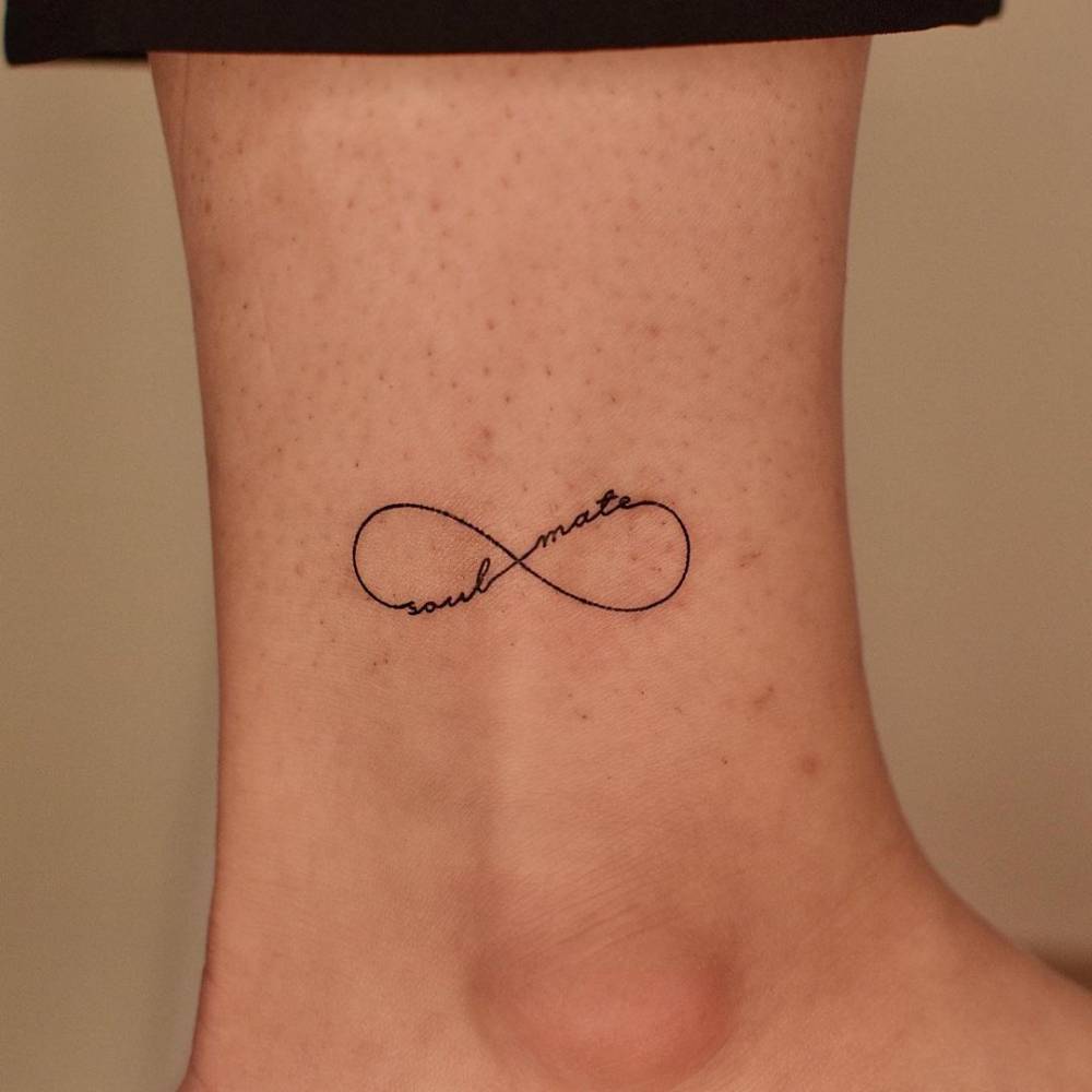 Fine line infinity symbol + "soul mate" tattoo