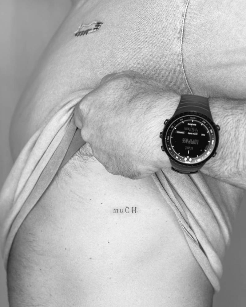 "Much" lettering tattoo on the rib