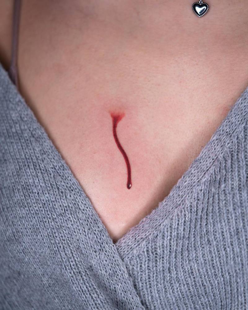Micro-realistic blood tattoo on the breast.