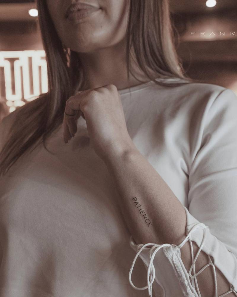 "Patience" lettering tattoo on the forearm.