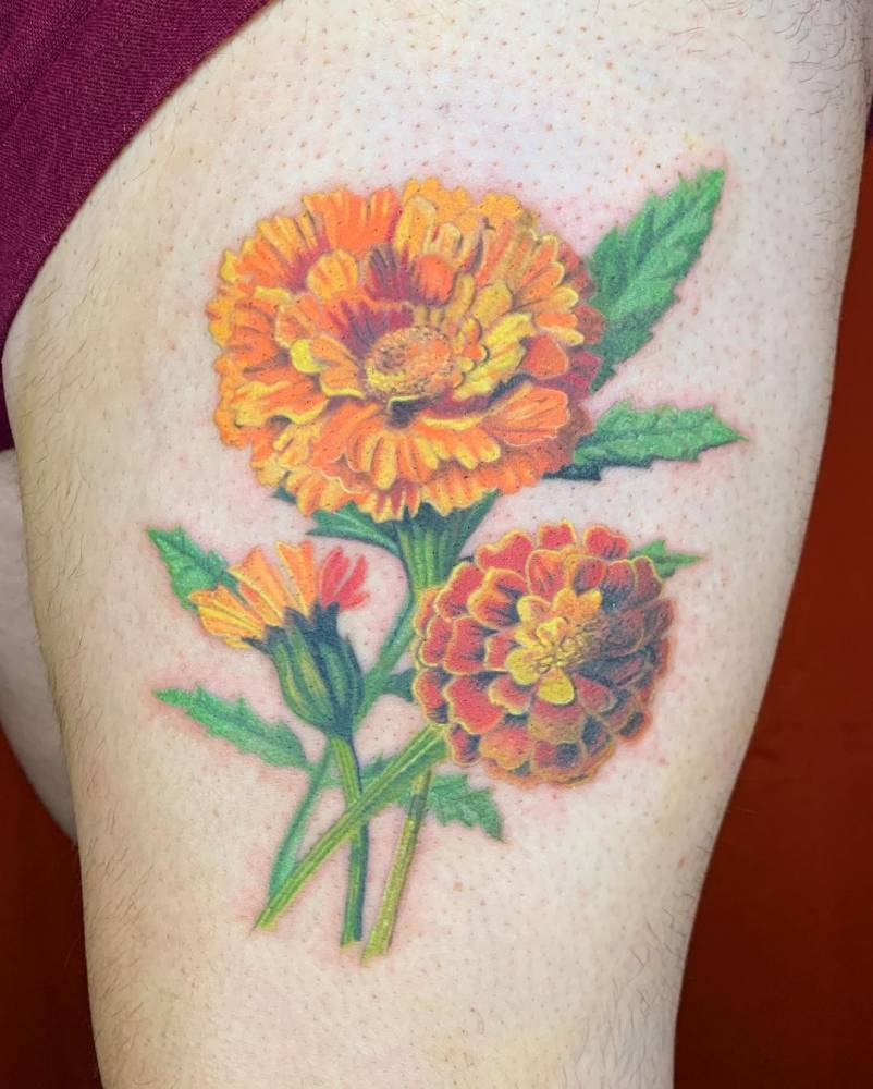 Healed realistic marigolds tattoo on the thigh.