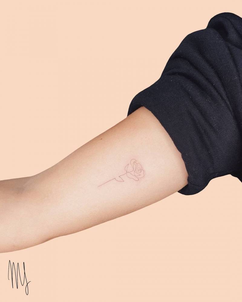 Minimalist one line rose tattoo on the inner arm.