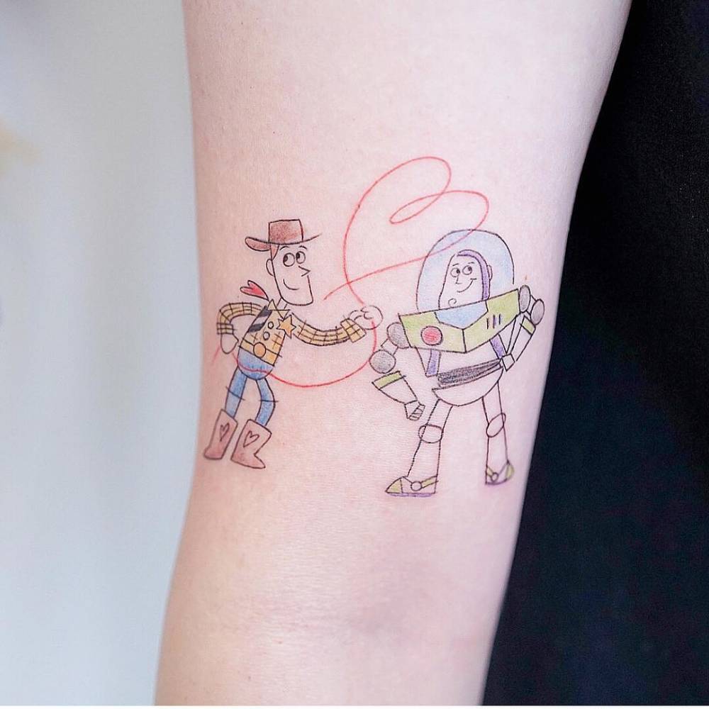 Woody and Buzz Lightyear tattoo on the bicep.ing #girltattoo