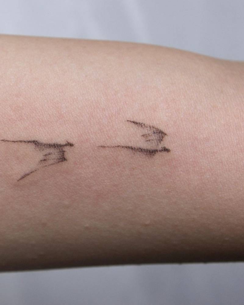 Hand poked minimalist dragon tattoo on the inner arm.