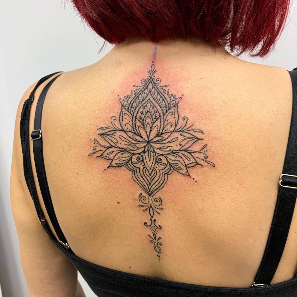 Ornamental lotus flower tattoo on the upper back.