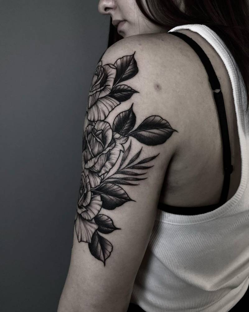 Blackwork roses tattoo on the upper arm.