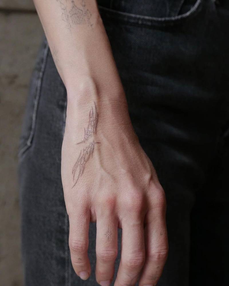 Single needle tribal tattoo on the hand.