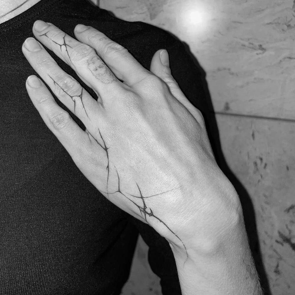 Single needle freehand tribal tattoo on the hand and fingers.