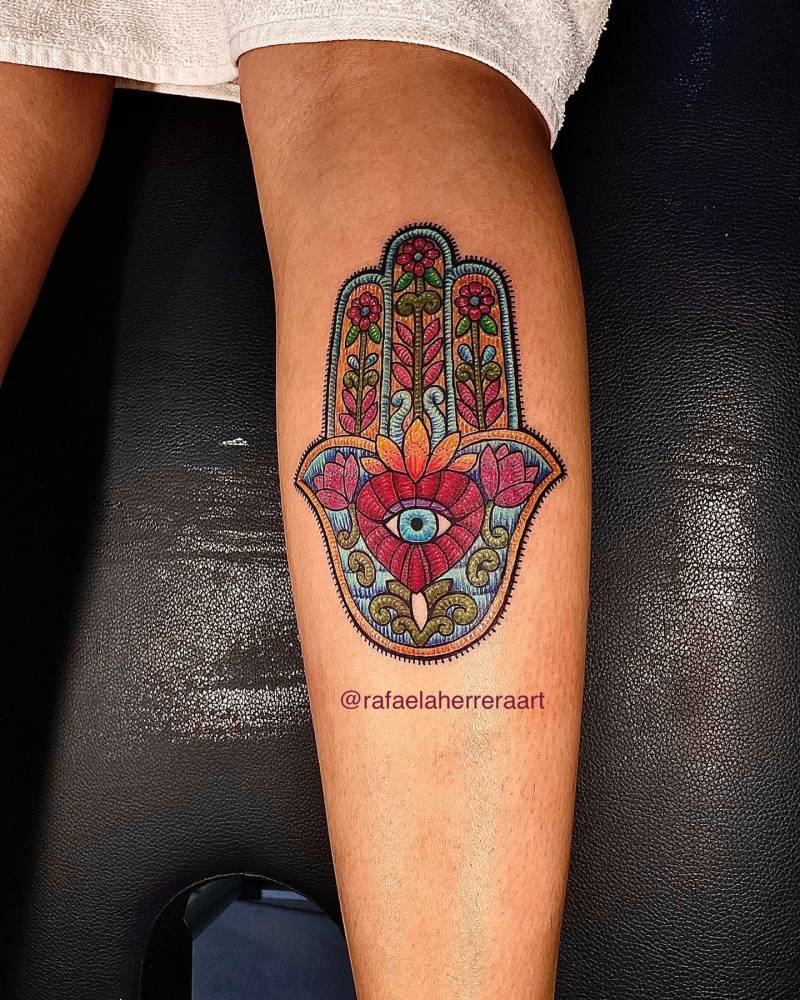 Embroidery style Hamsa tattoo located on the calf.
