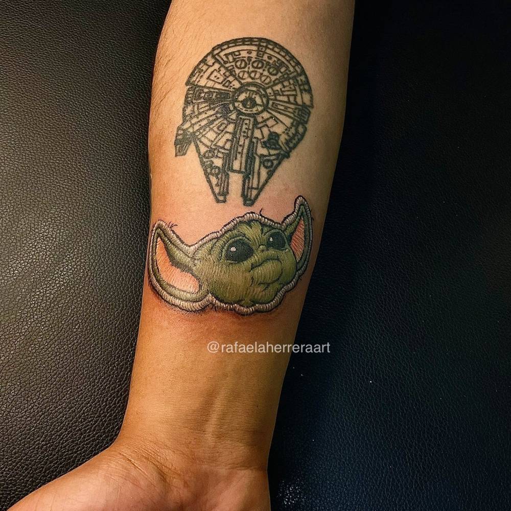 Baby Yoda patch tattoo in embroidery style located on the wrist.
