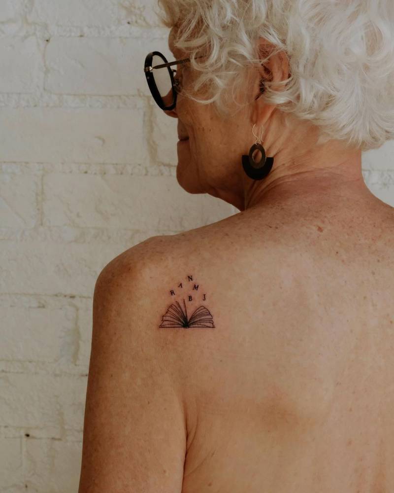 Fine line style book tattoo located on the shoulder blade.