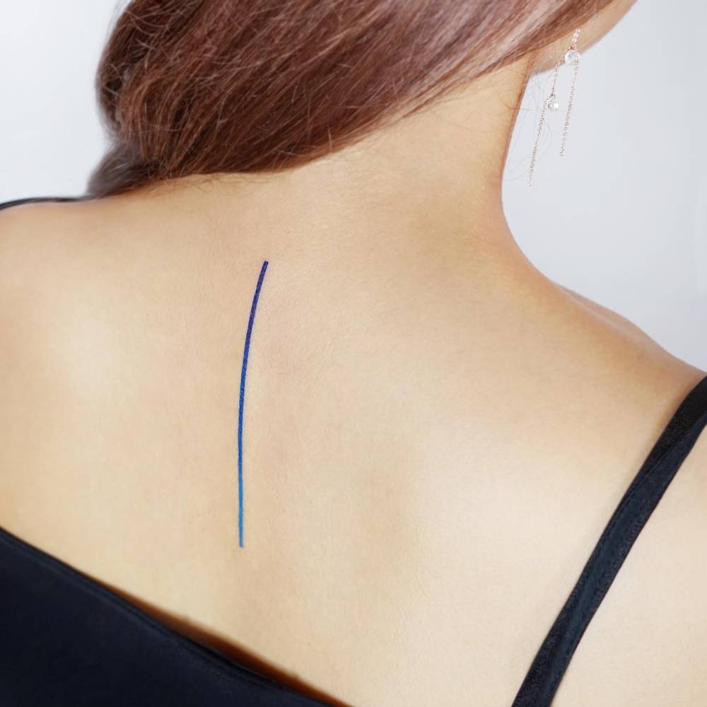 Thin spectrum line tattoo done on the upper back.