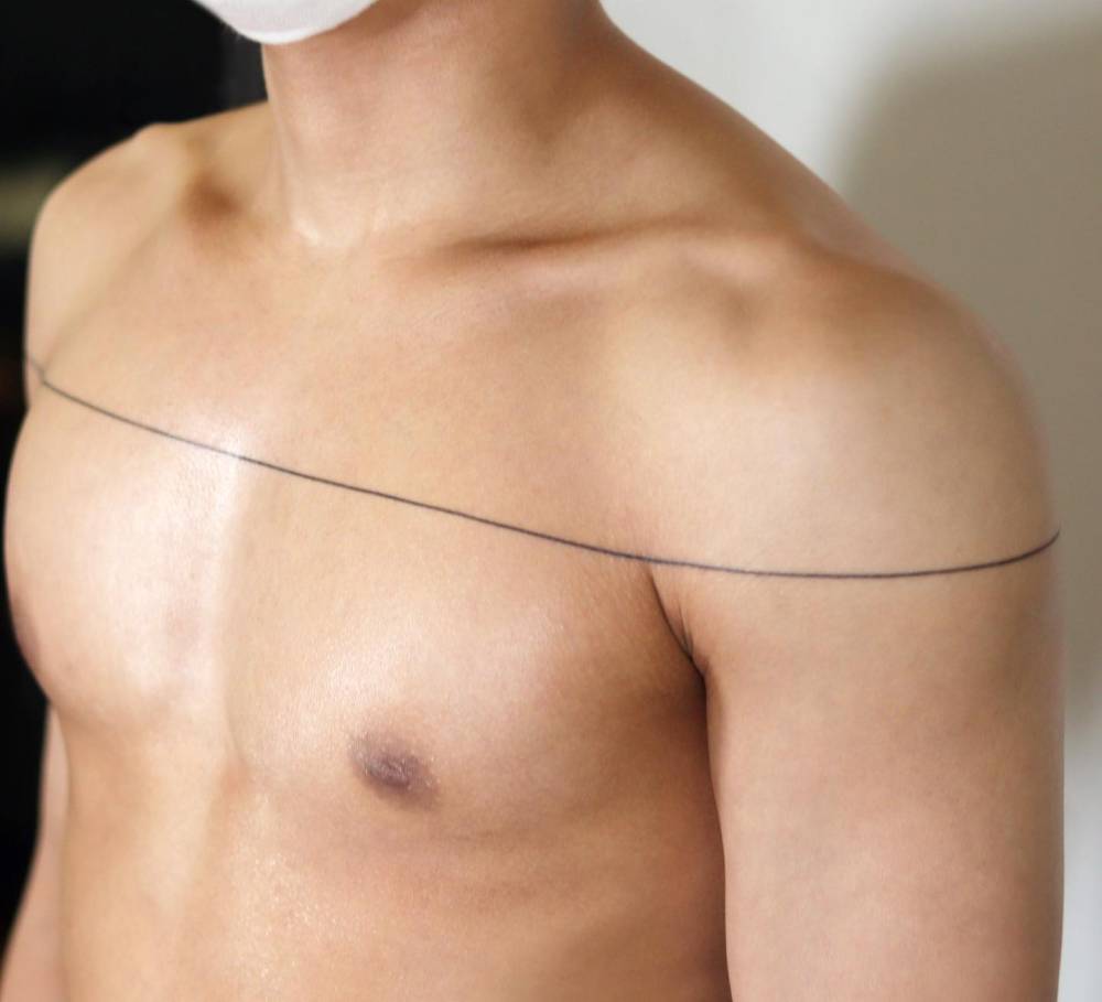 Minimalistic style line tattoo located on the chest.
