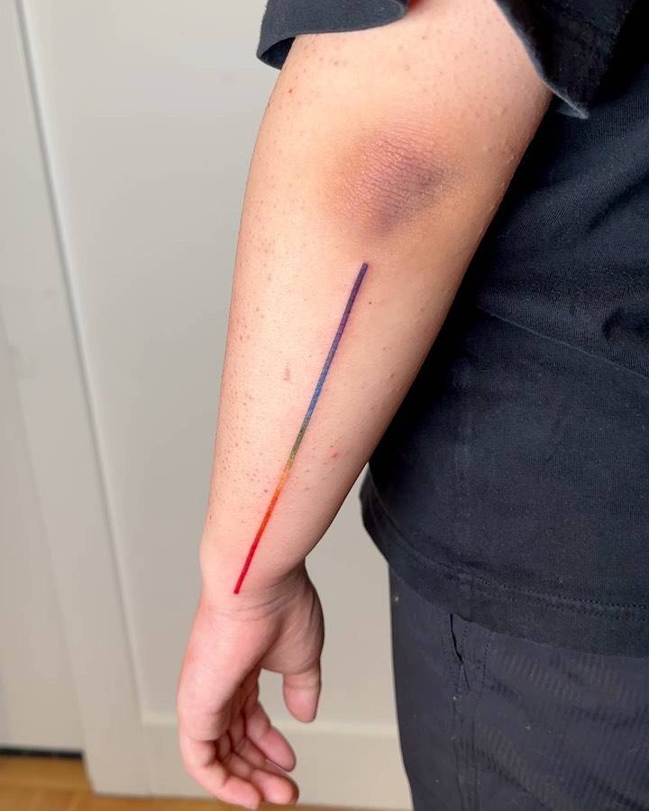 Visible spectrum line tattoo located on the forearm.