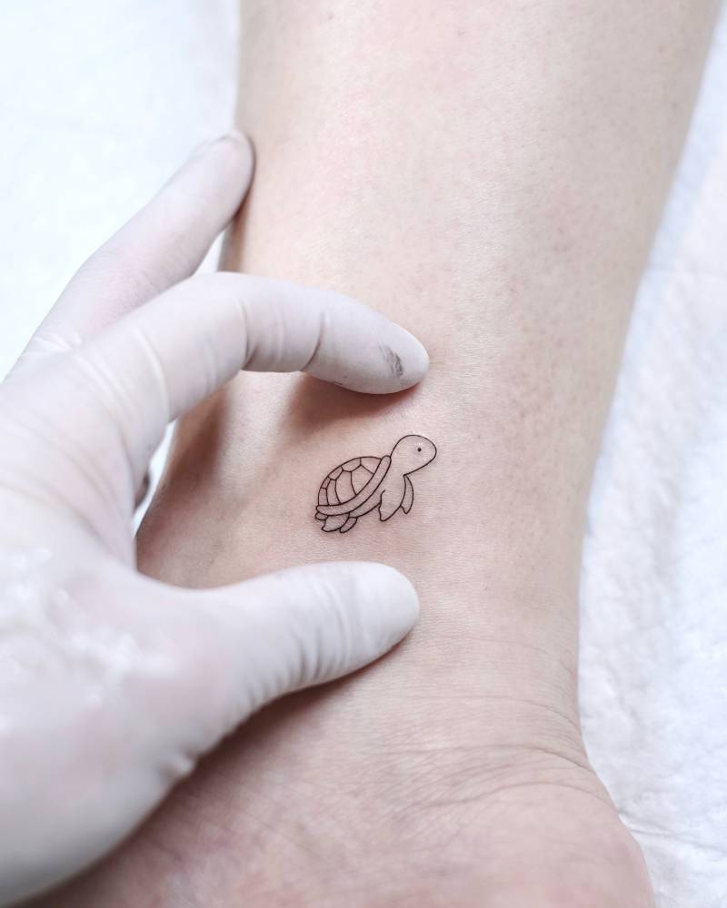 Minimalistic turtle tattoo located on the ankle.