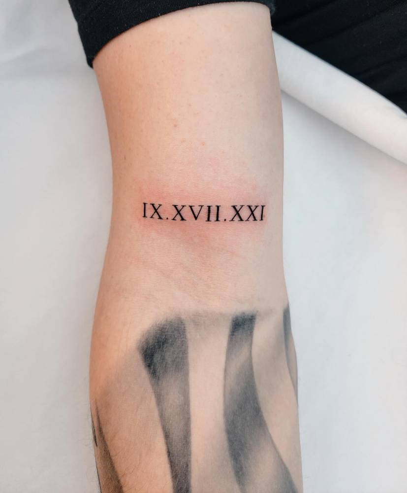 Date in roman numeral tattooed on the bicep.