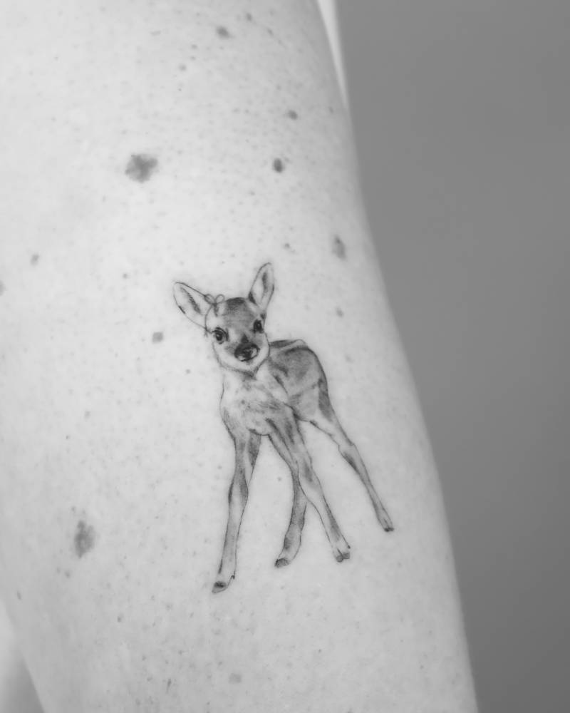 Fawn tattoo located on the upper arm, illustrative style.