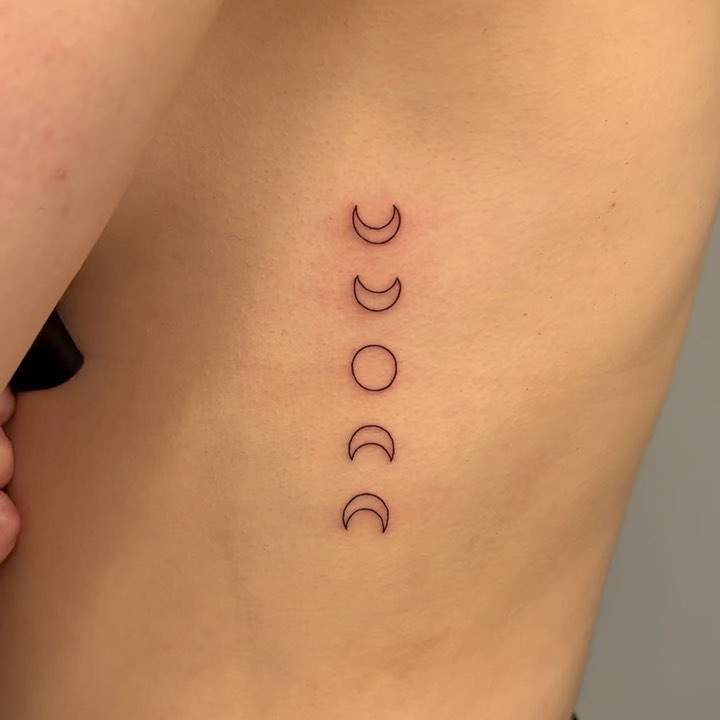 Minimalistic style moon phases tattoo done on the rib.
