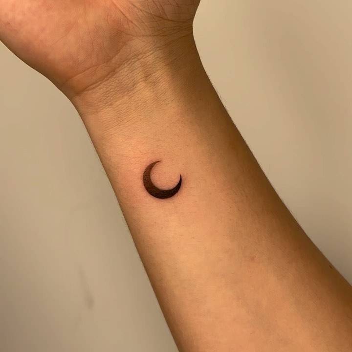 Spectrum moon tattoo done on the wrist, minimalitic style.