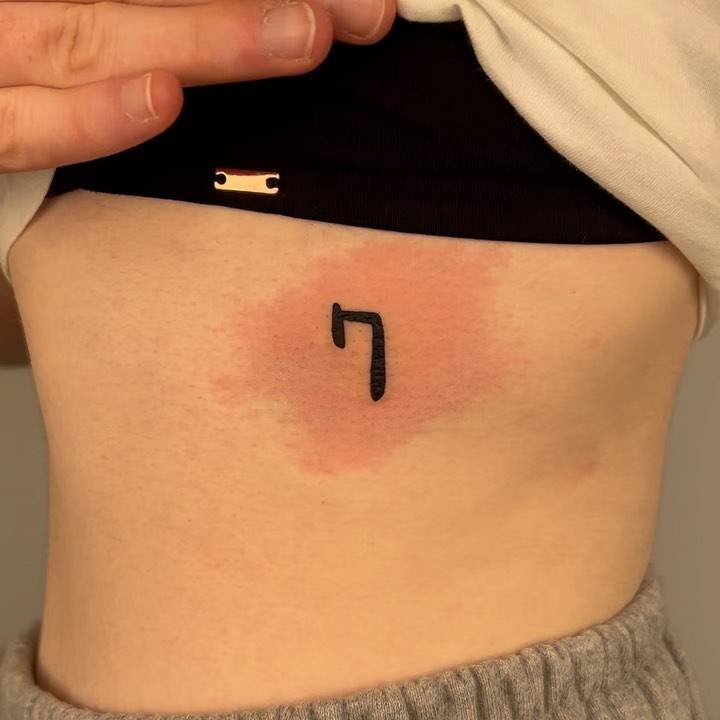 Tattoo of the number "7" located on the rib.