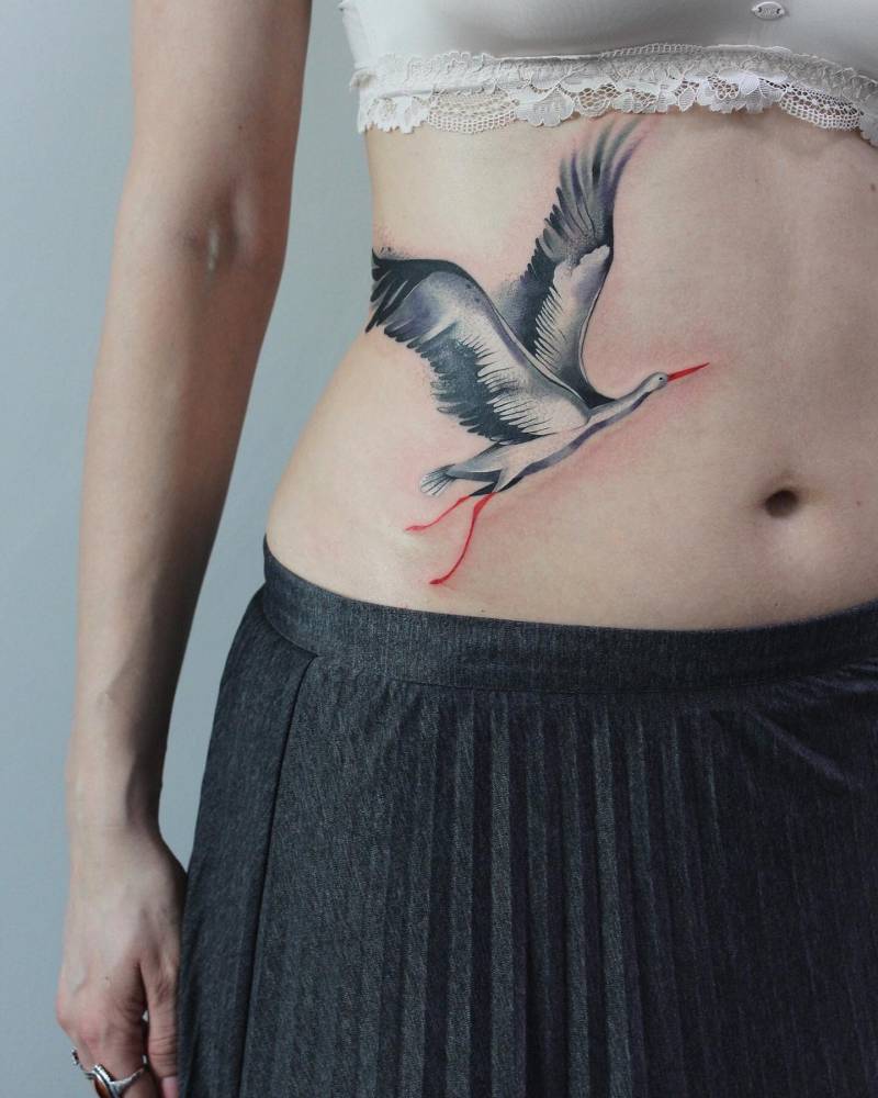 Watercolor style stork tattoo done on the waist.