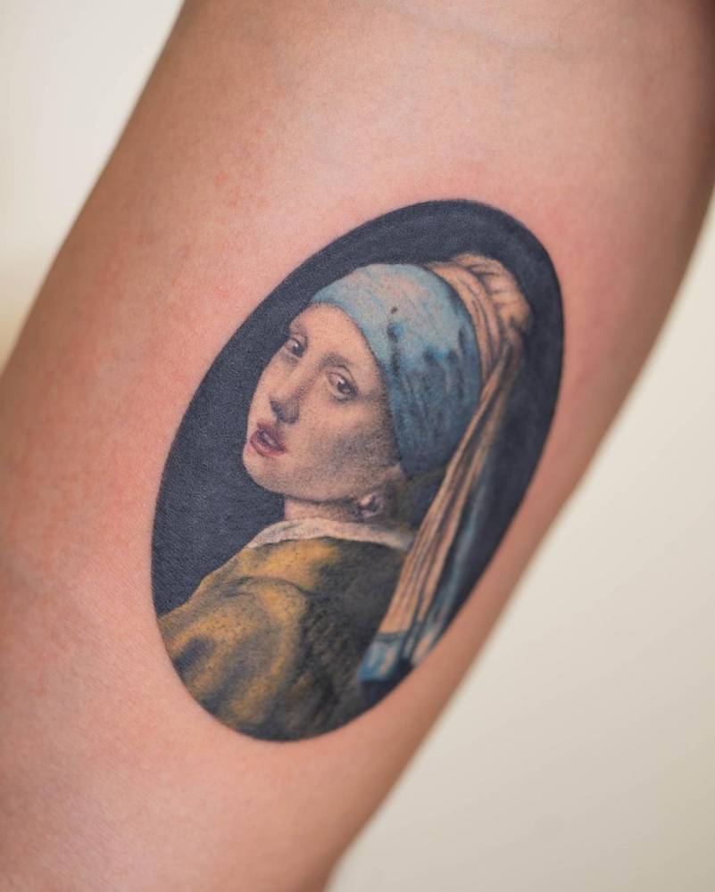 'Girl With a Pearl Earring' tattoo on the inner arm.