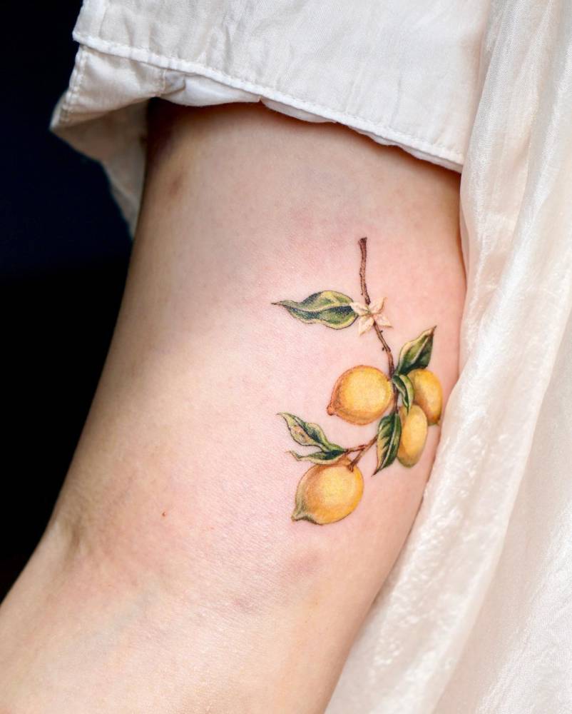 Lemons tattoo in watercolor style located on the inner arm.
