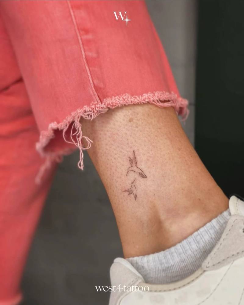 Fine line style hummingbirds tattoo located on the ankle.