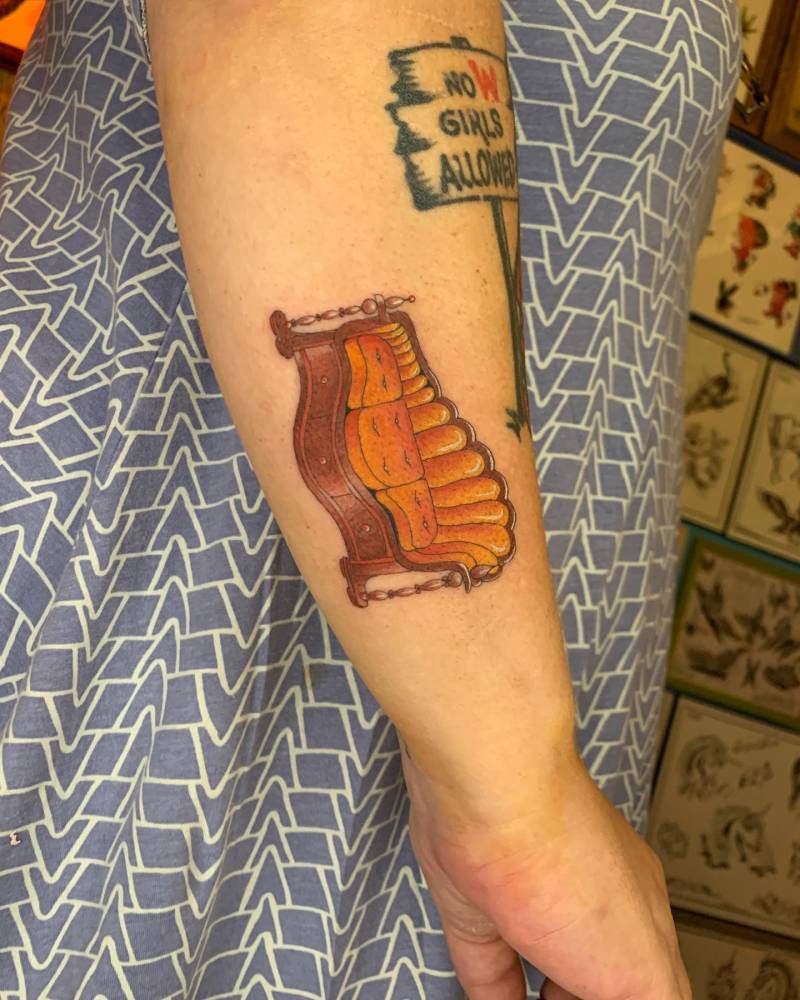 Couch tattoo located on the forearm.