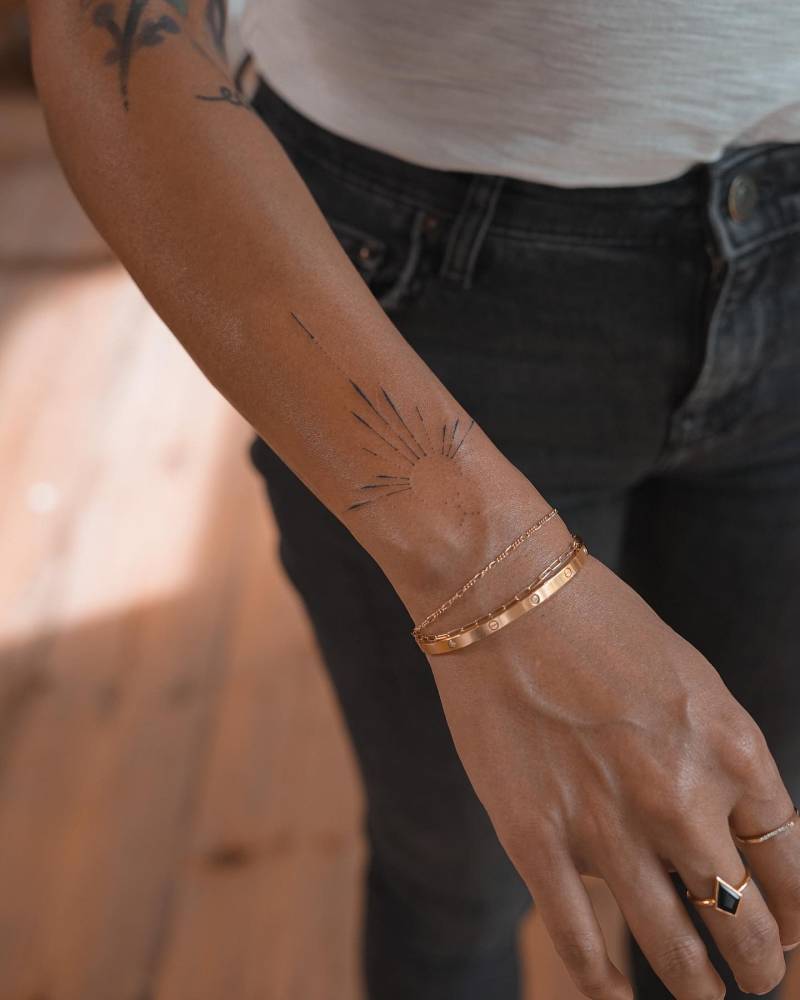Hand poked ornament tattooed on the wrist.