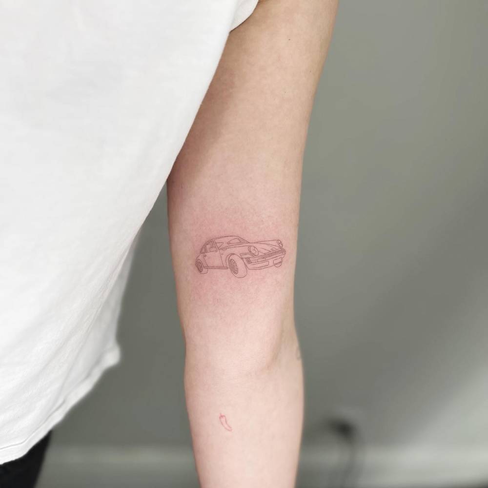 Porsche 911 tattoo located on the inner arm, fine line style.