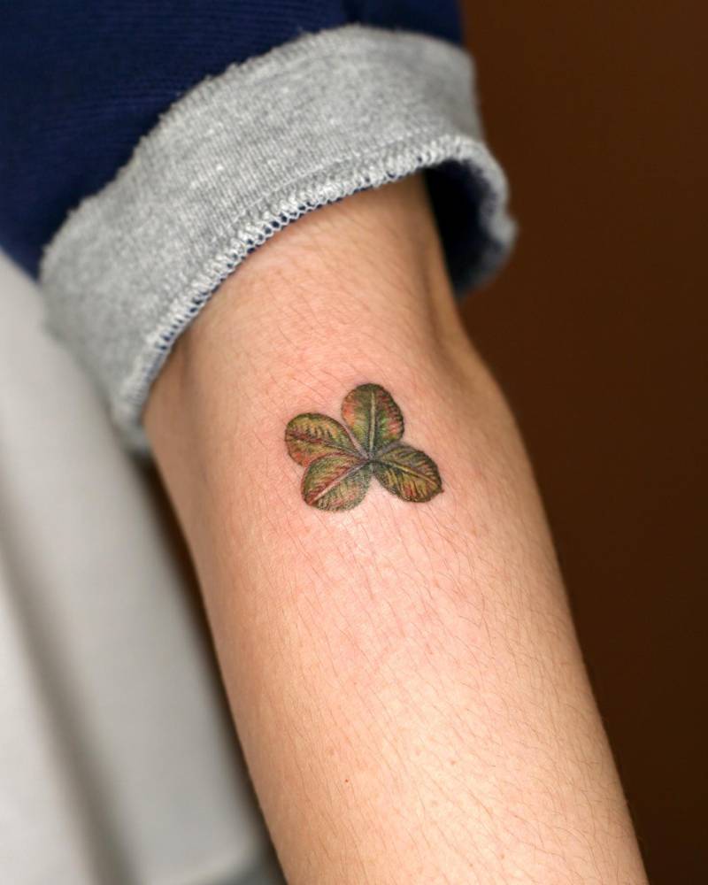 Watercolor style four leaf clover tattoo done on the forearm.