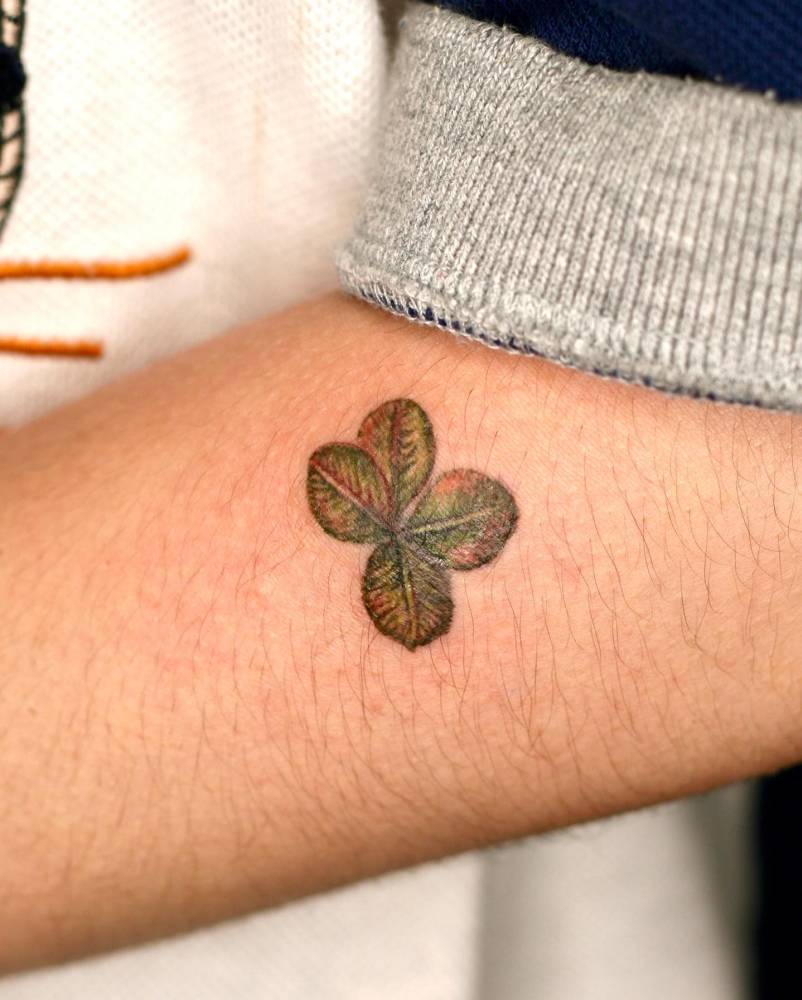 Watercolor style four leaf clover tattoo done on the forearm.