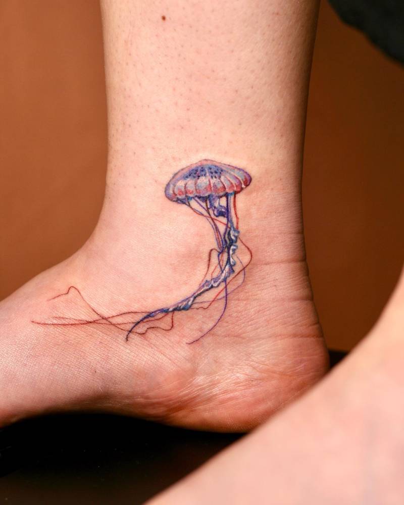 Watercolor style jellyfish tattoo located on the ankle.