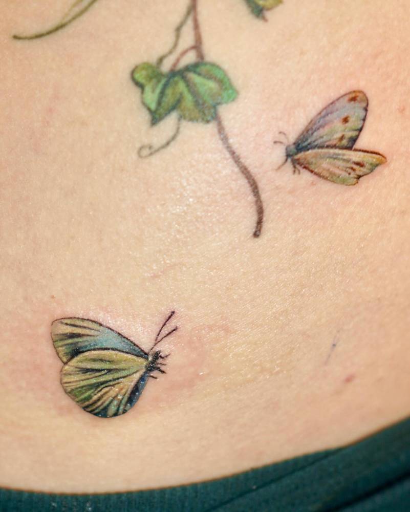 Watercolor style butterfly couple tattoo located on the back.