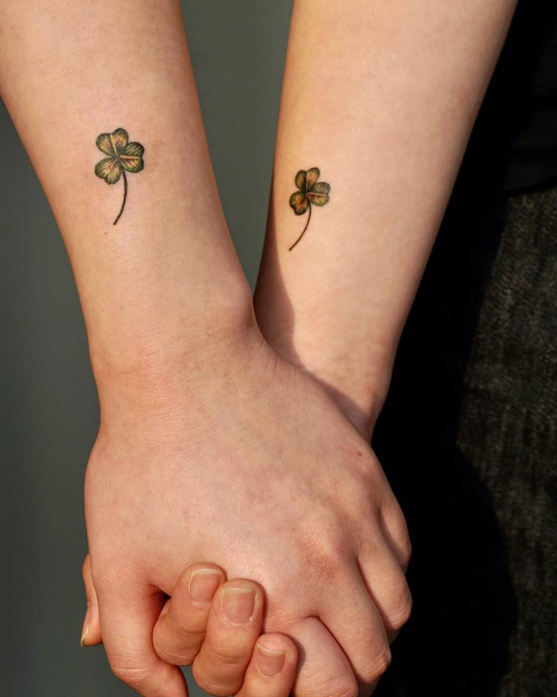 Matching three leaf clover tattoo for couple.