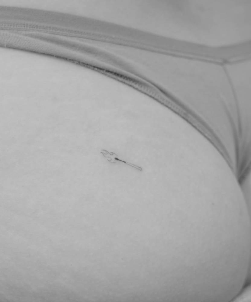 Minimalistic style matchstick tattoo located on the butt cheek.