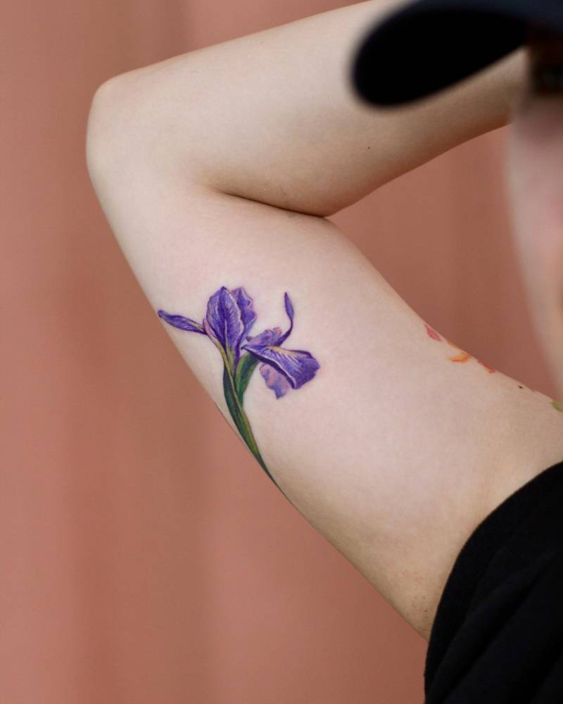 Iris tattoo in watercolor style placed on the inner arm.