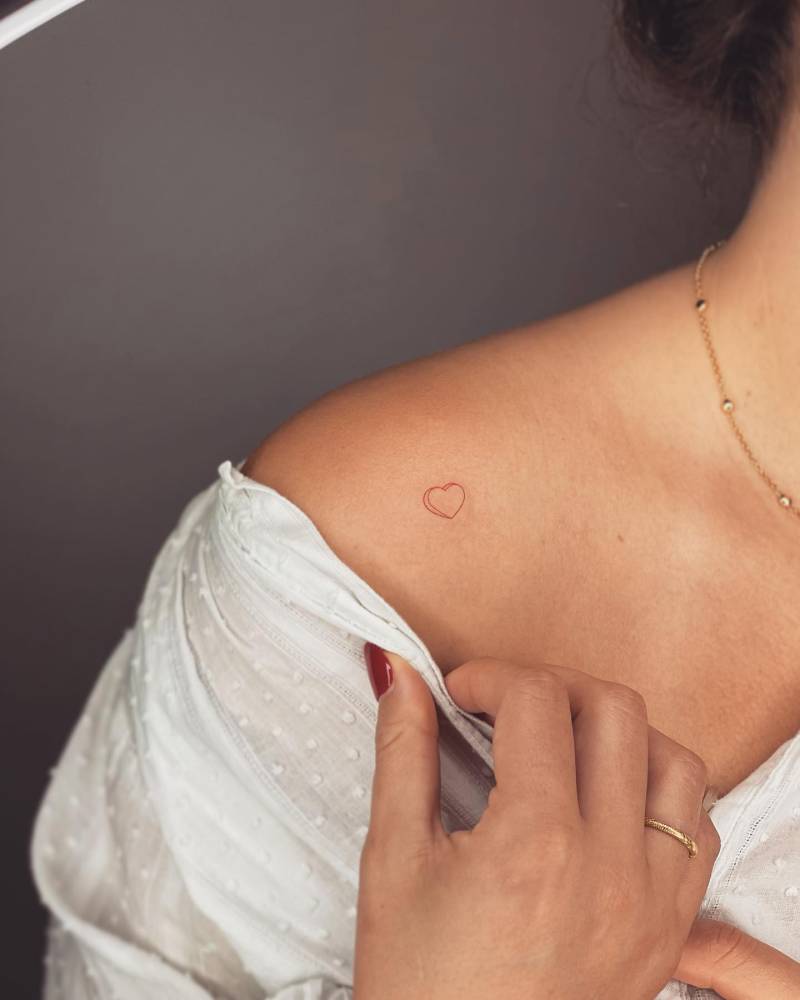 Tiny red sweetheart tattoo located on the shoulder.