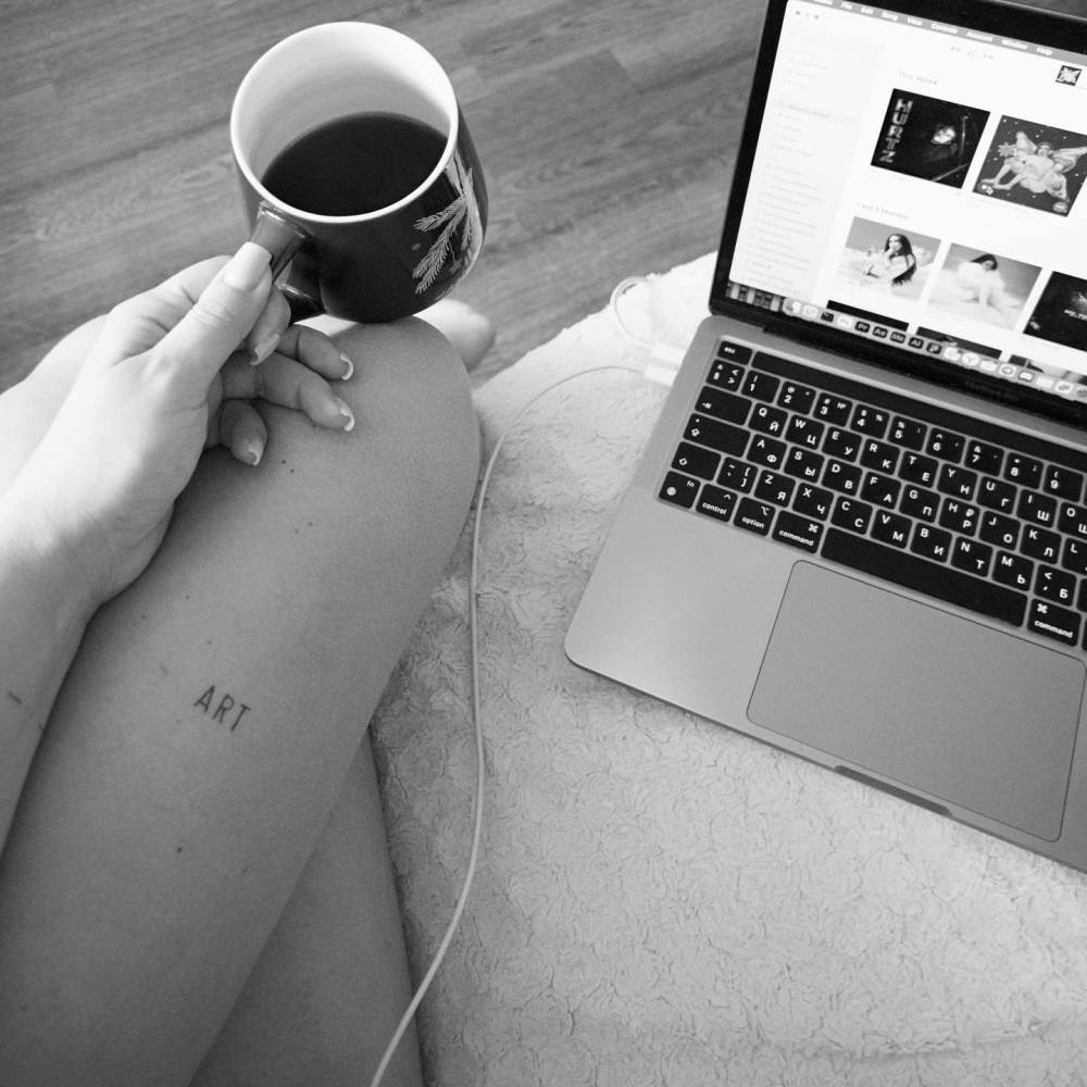 Healed tattoo of the word "art" located on the thigh.