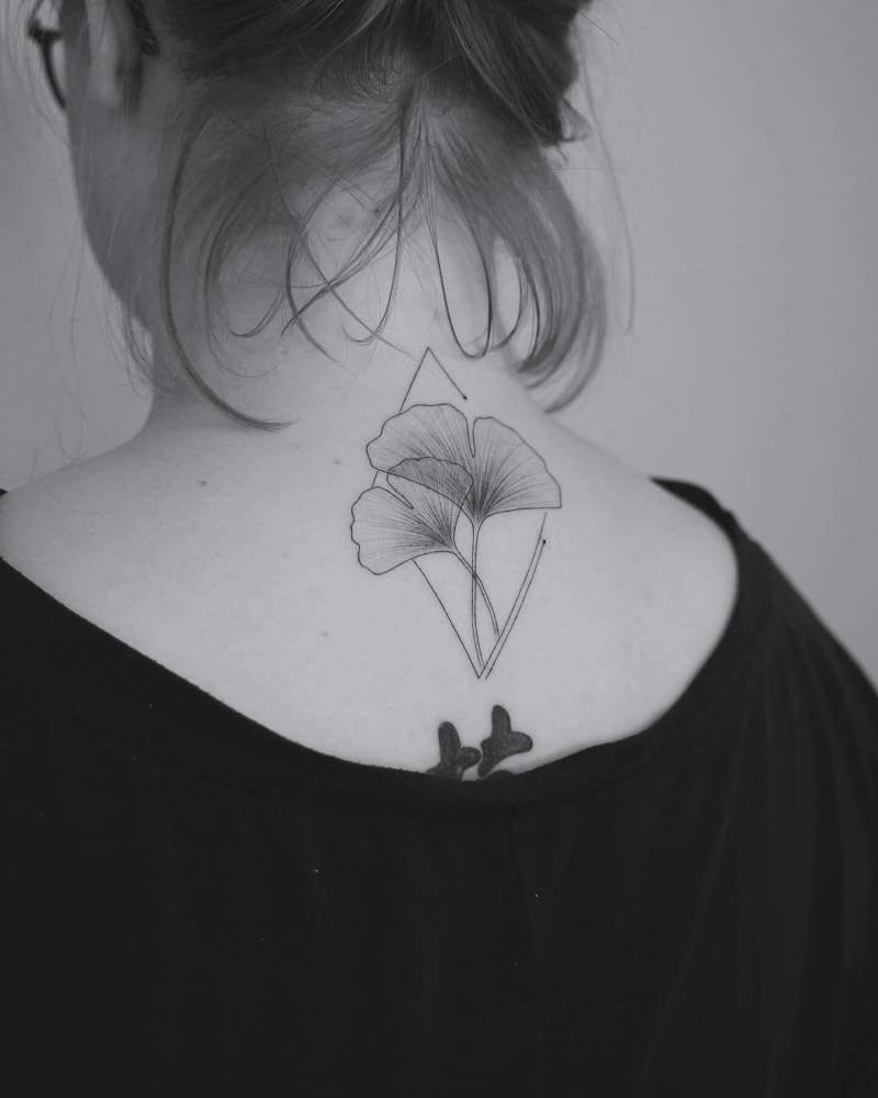Illustrative style Ginkgo leaves tattooed on the upper back.