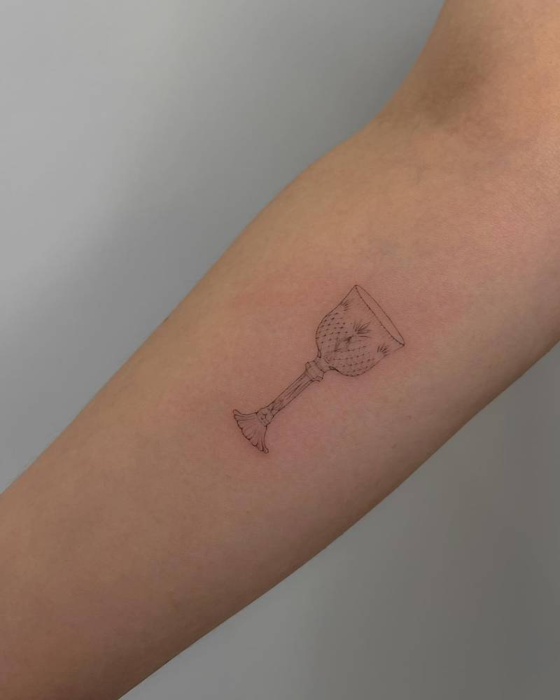 Fine line style chalice tattoo placed on the inner forearm.
