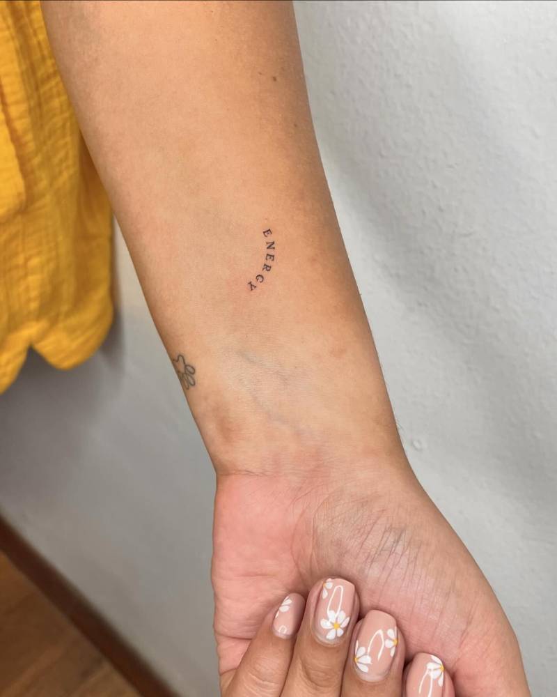 Lettering tattoo of the word "energy" located on the wrist.