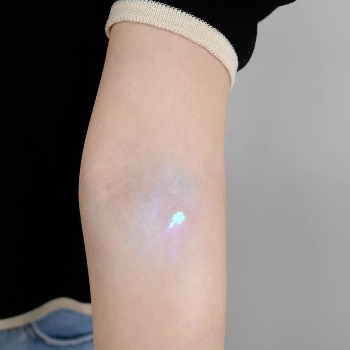 Micro UV ink four leaf clover tattoo located on the inner forearm.