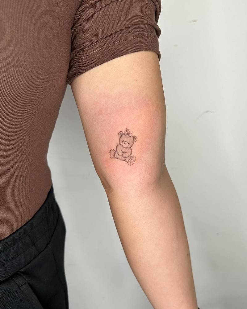 Illustrative style teddy bear tattoo located on the inner arm.