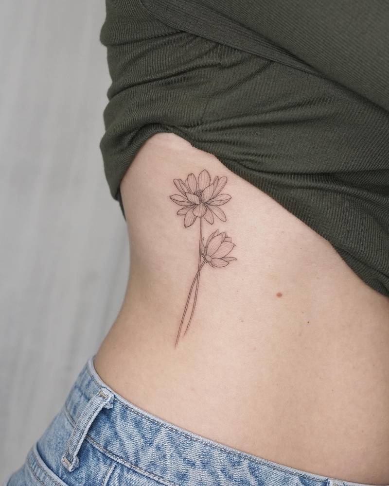 Lotus flower tattoo located on the rib, illustrative style.