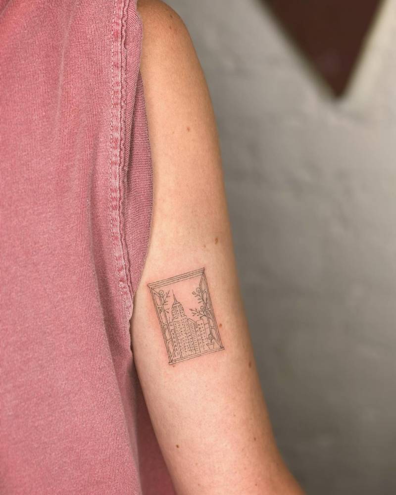 New York City Frame tattoo located on the bicep, fine line style.