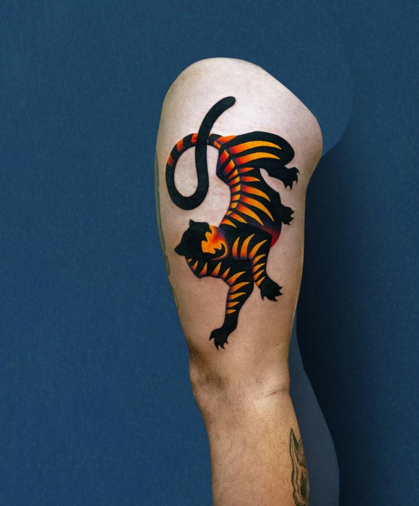 Pop art style tiger tattoo located on the thigh.